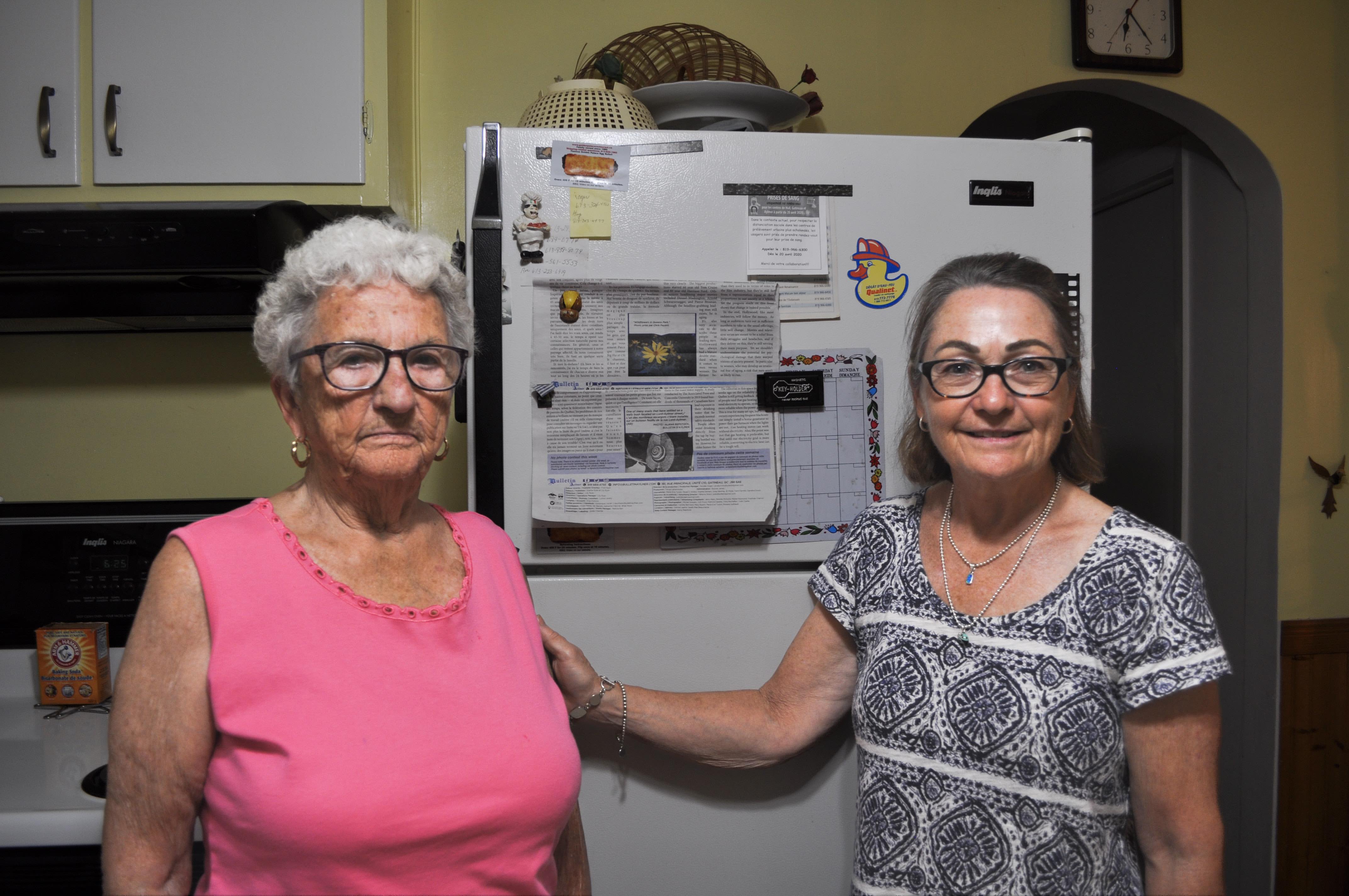 Christine Payant with her mother, Yvonne Bourgeau, standing in the latter's kitchen.