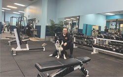 Lyne Monette, propriétaire de M Fitness, en compagnie de Koda, la mascotte bien-aimée du gym, dans l’espace d’entraînement nouvellement agrandi. Crédit photo : Sophie Demers