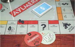 Tous ceux qui jouent une partie d’Aylmerpoly obtiennent un sous-verre à l’effigie du jeu donnant droit à un rabais de 10 % sur l’achat de canettes pour emporter à la microbrasserie 5e Baron. Crédit photo : Christian Rochefort